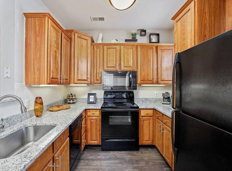 Gourmet Kitchens with Raised Panel Cabinetry, Granite Like Countertops, Black Appliance Packages and Lighting at Cambridge Square Apartments, Overland Park, KS 66211
